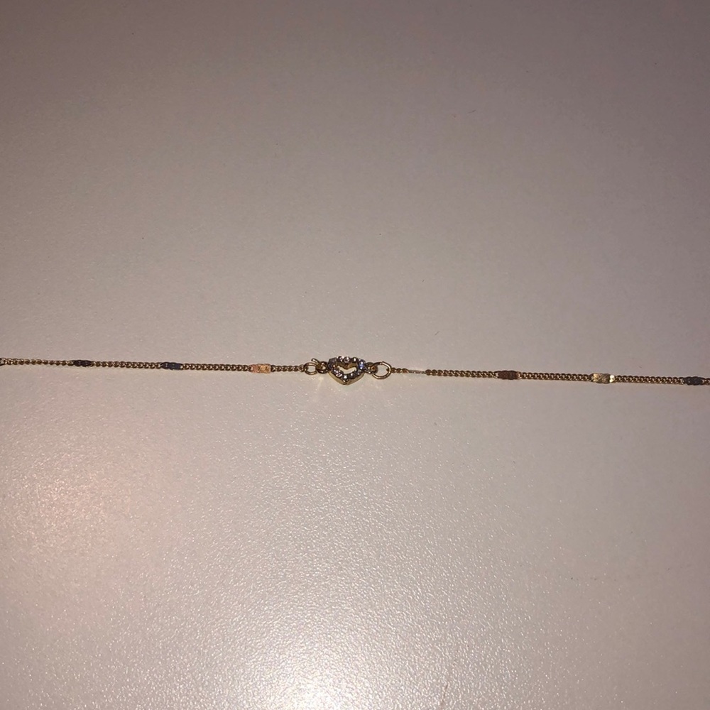 This is a gold necklace with a heart jewel